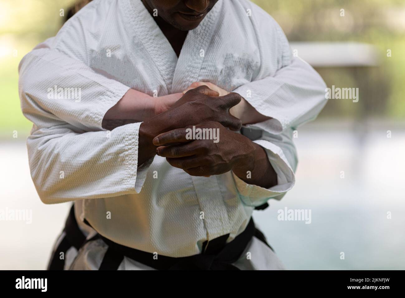 A closeup of two men in kimono showing hand grip tactics for self