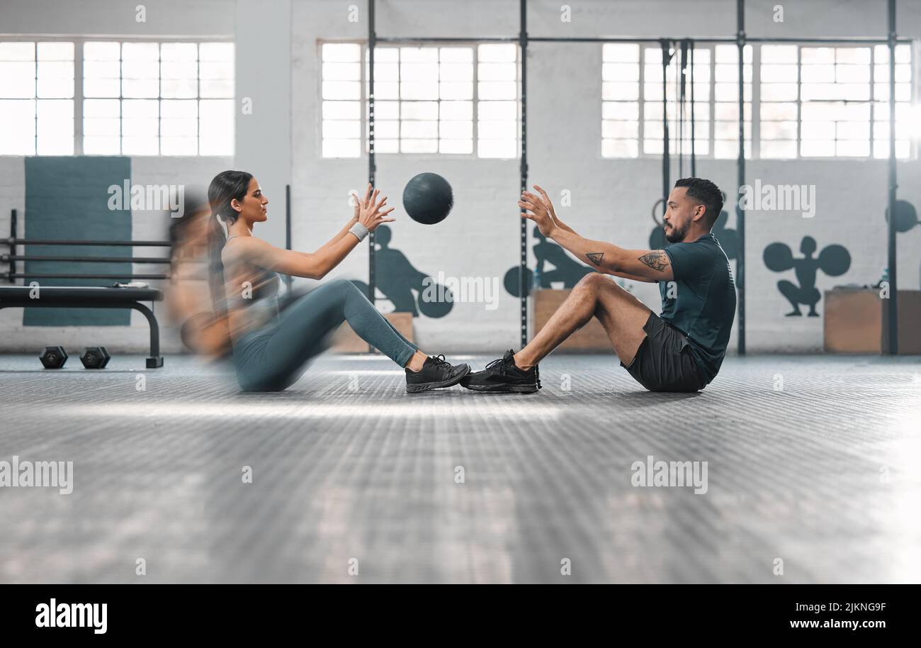 Active, sporty fitness couple or gym partners training together, doing abs  exercises by throwing a weighted slam ball. Male trainer and female athlete  Stock Photo - Alamy