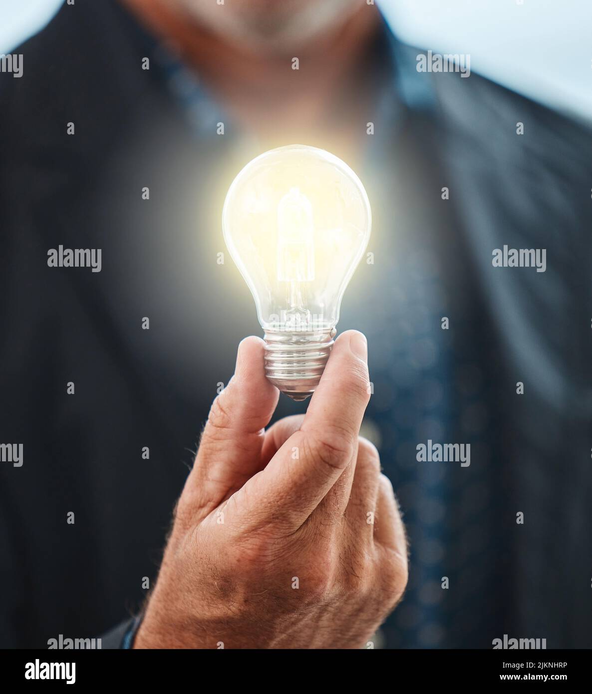 The creative mind can overcome anything. an unrecognisable businessman holding a lightbulb. Stock Photo