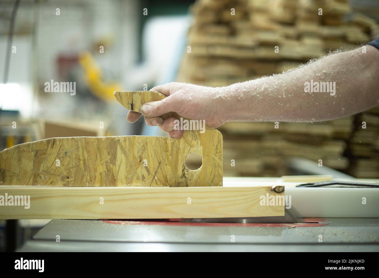 Wood processing. Chipping board. Manufacture of furniture. Joinery. Hand holds board. Sawing board. Stock Photo