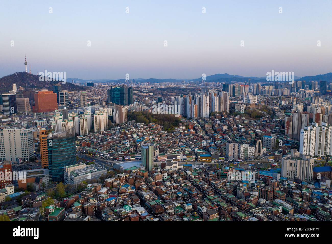 An aerial cityscape of Seoul surrounded by buildings in background of mountains Stock Photo
