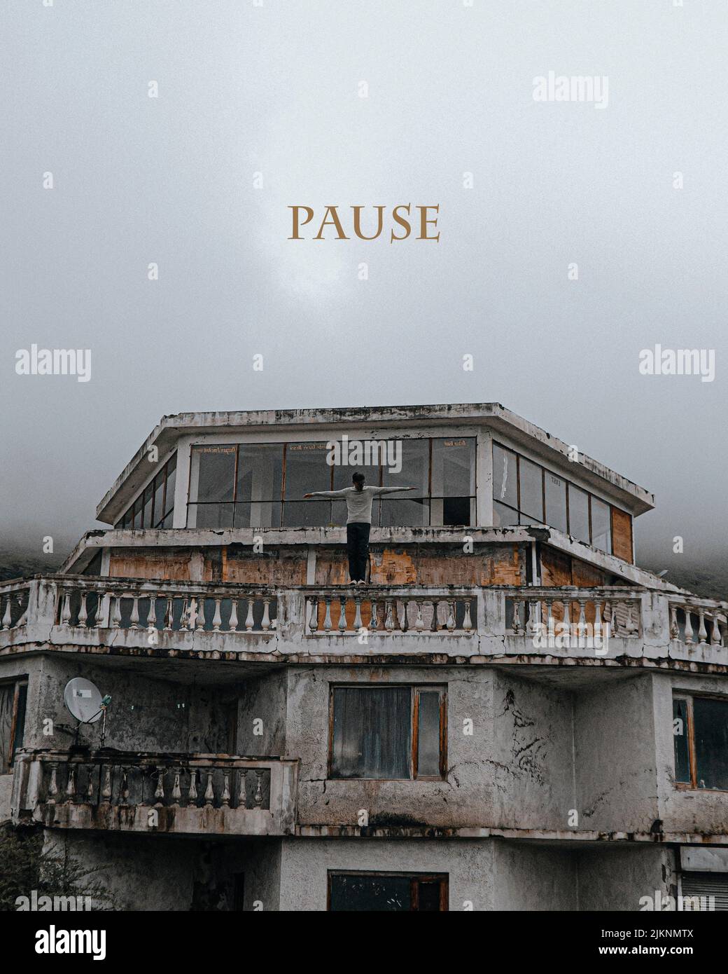 A vertical shot of a person on the abandoned building with a pause sign over it Stock Photo