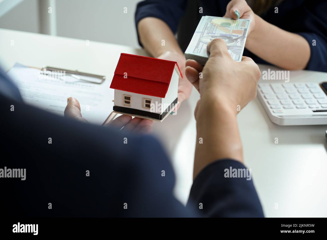 A male buyer pays his down payment for his property to a female real estate agent. cropped image Stock Photo