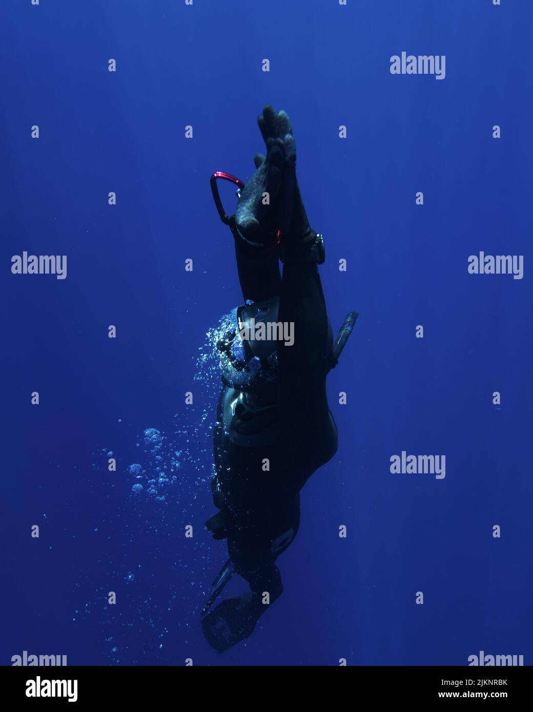 A vertical view of a person in diving equipment exploring the