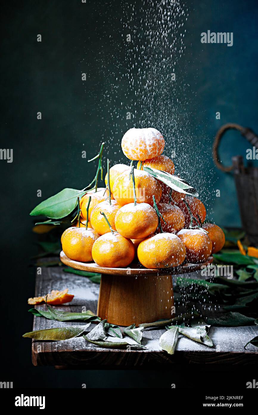 A beautiful shot of mandarins laid in a pyramid shape with a sifted powdered sugar Stock Photo