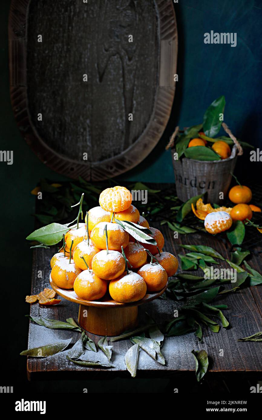 A beautiful shot of mandarins laid in a pyramid shape with a powdered sugar Stock Photo