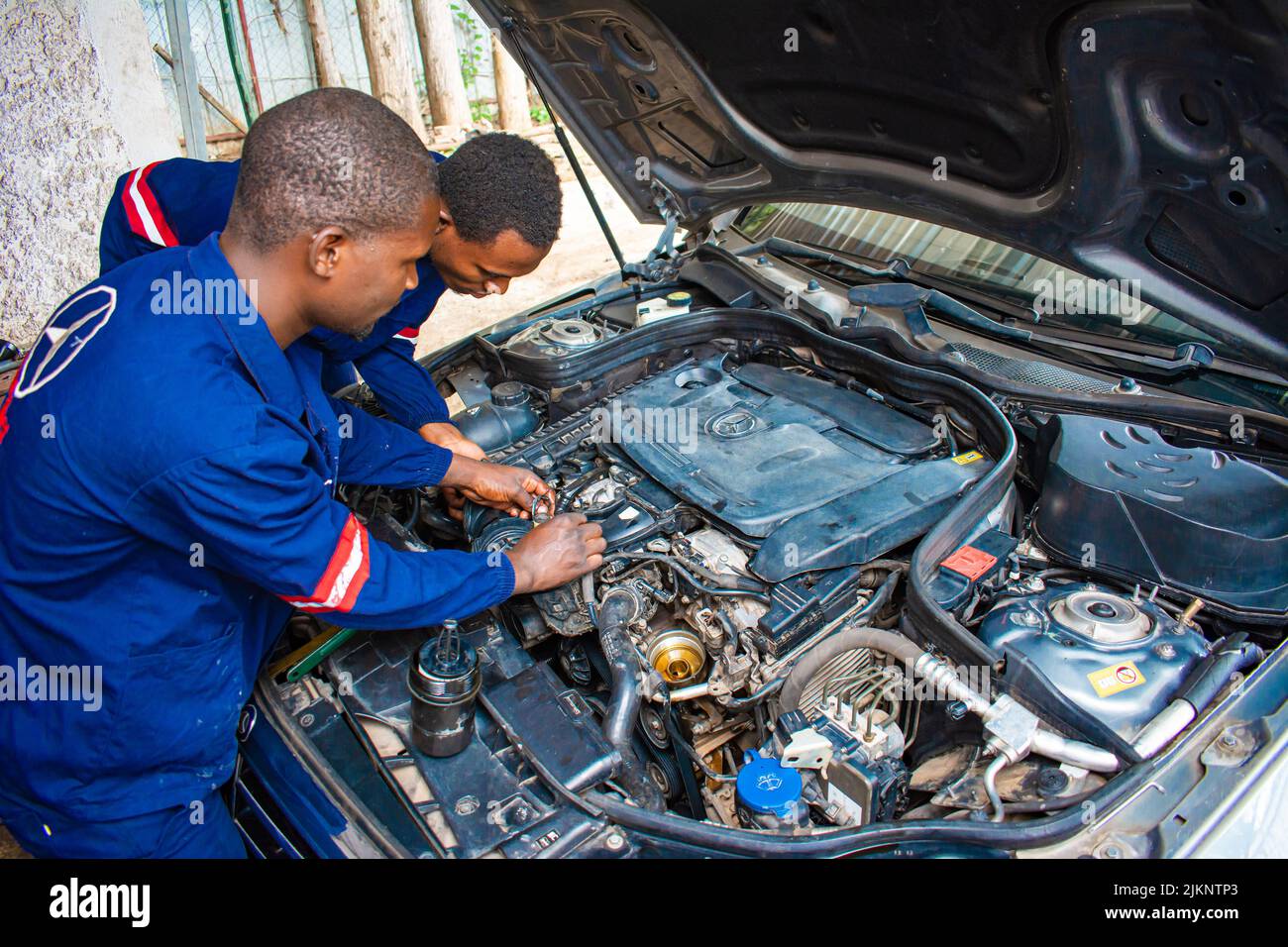 The auto mechanics working on the car system in Zimbabwe Stock Photo