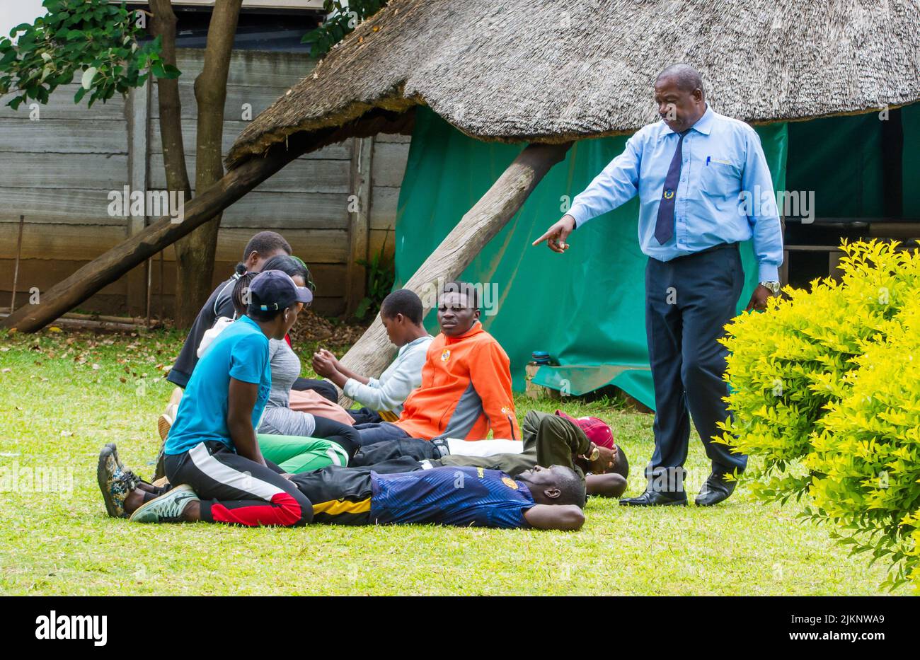 A closeup shot of a male security guard training young males in Harare, Zimbabwe Stock Photo