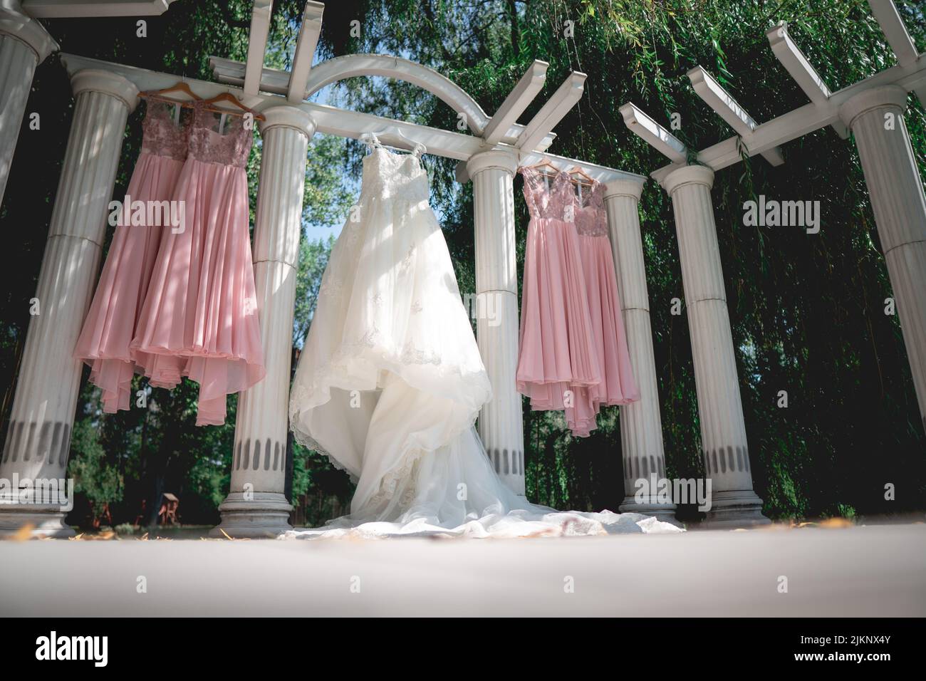 The dresses of the bride and the bridesmaids hung at the venue Stock Photo