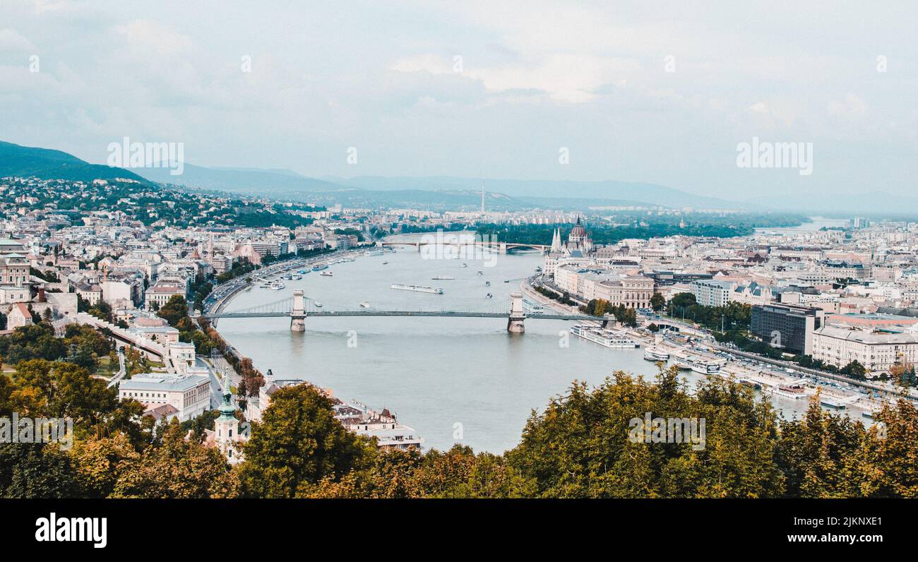 An aerial view of the cityscape and a bridge over the river against the ...