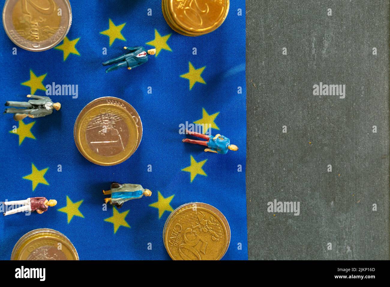 Taxpayers of EU countries.figurines of people and euro coins on european union flag background.Tax and price increases  Stock Photo