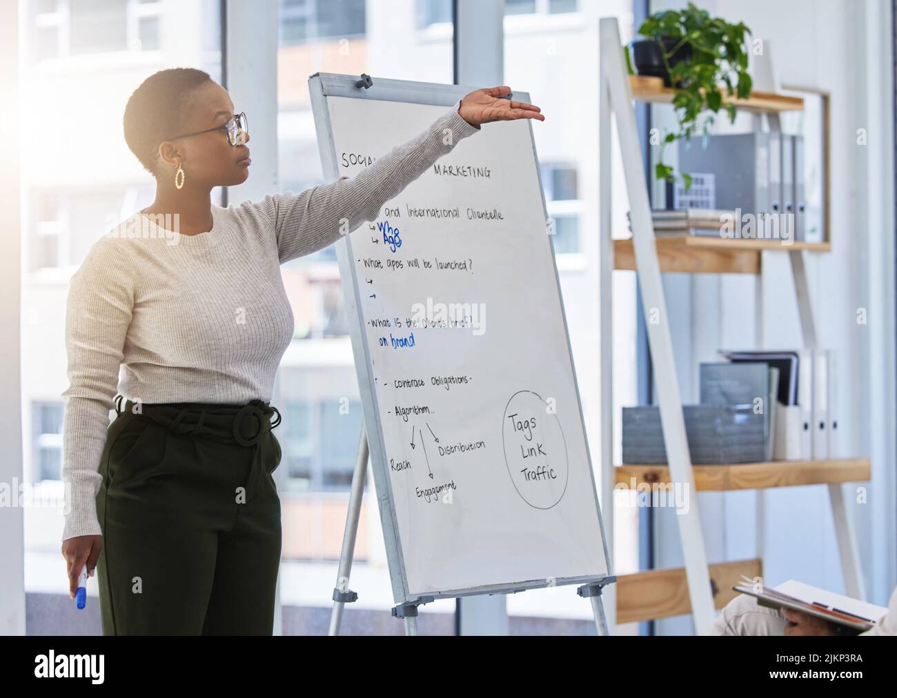 Any questions. a young woman giving a presentation in a modern office ...