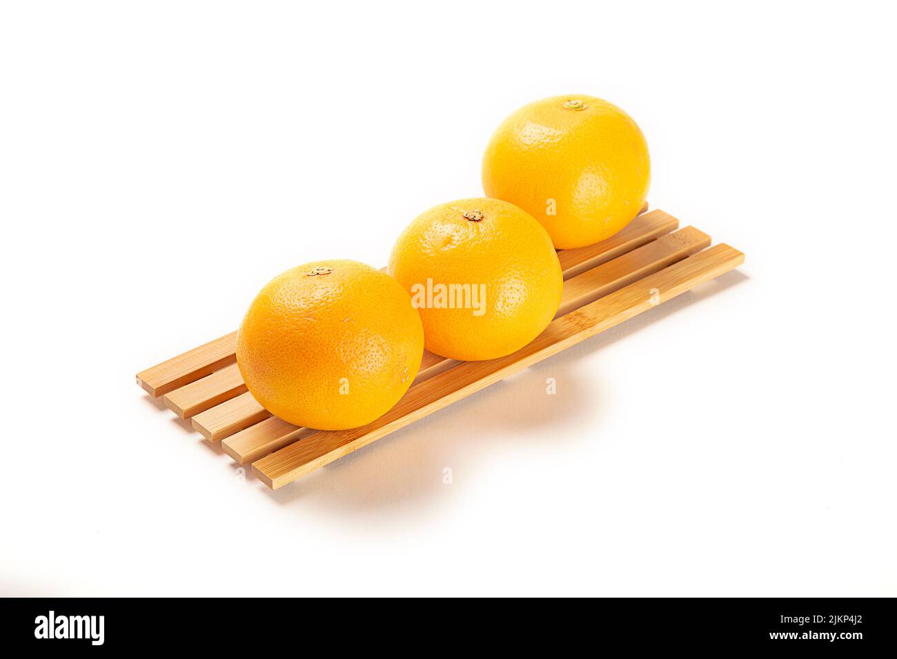Three fresh oranges on a board isolated on a white background Stock Photo
