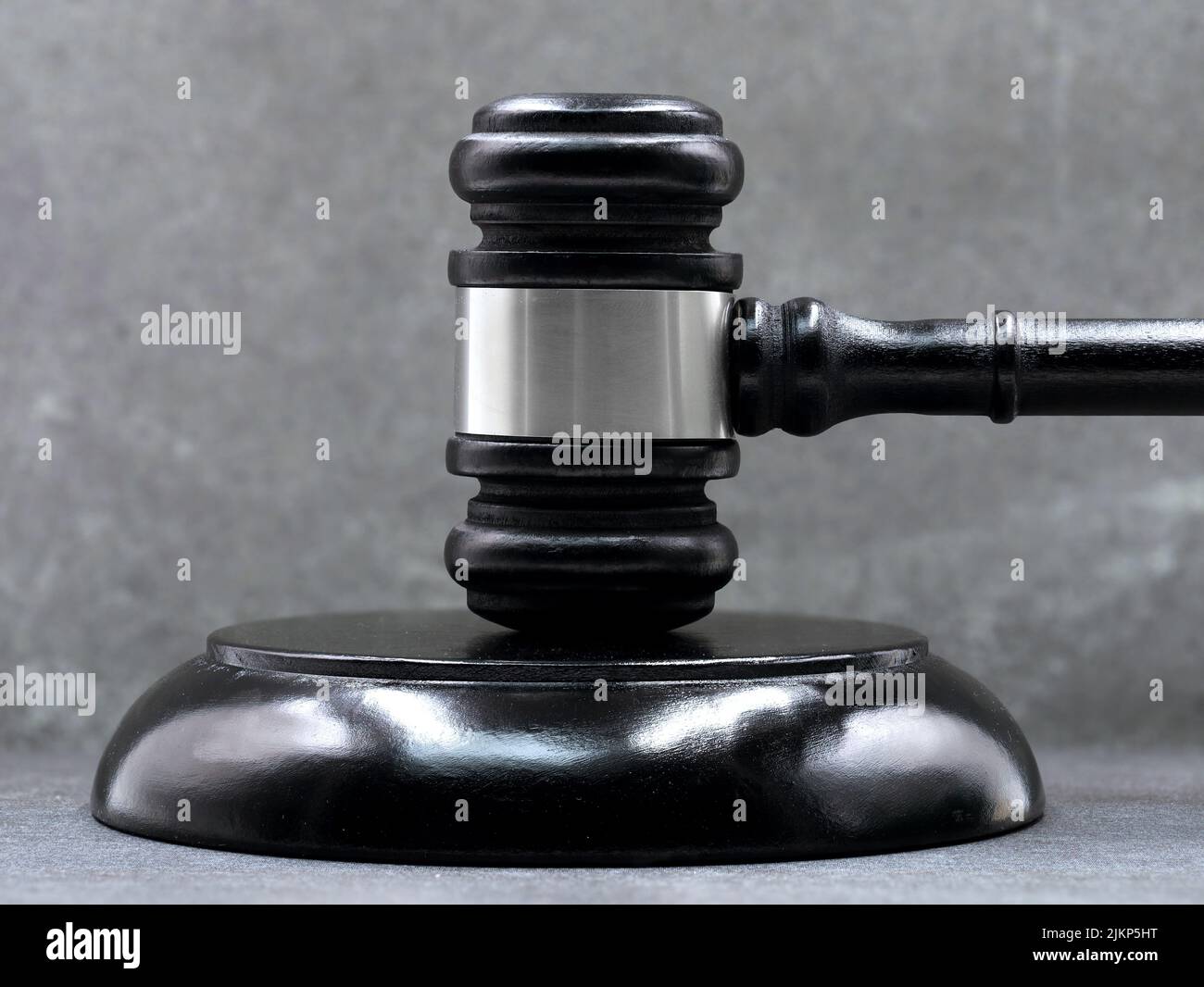 close up of black judge gavel against gray wall background Stock Photo
