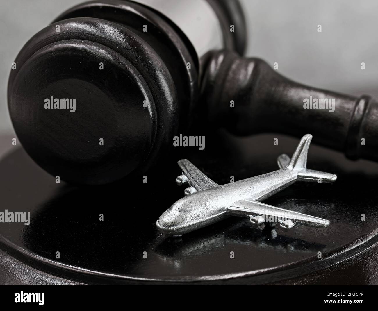 close up of judge gavel with silver airplane, concept of court decisions after flight cancellation and possible compensation claims Stock Photo