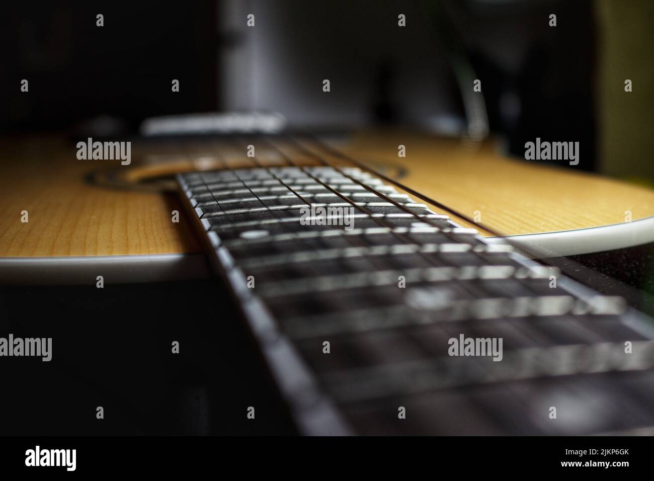 A closeup shot of an acoustic guitar neck on a blurry background Stock Photo