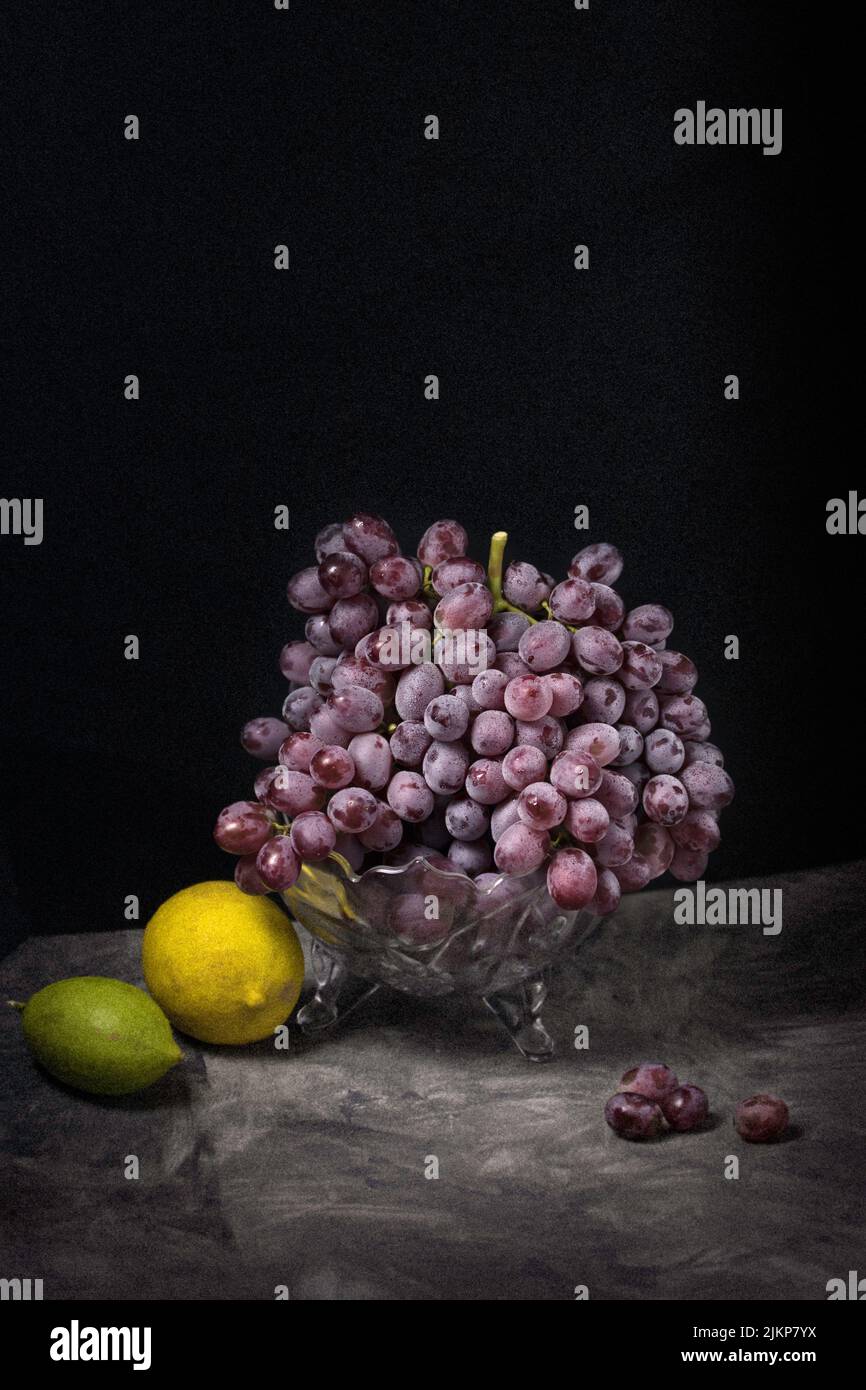 A closeup of grapes and lemons on a black background - still life Stock Photo