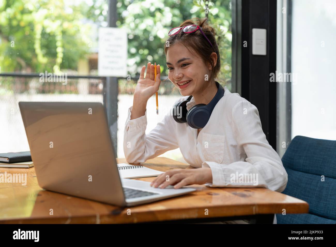 Online education, e-learning. young woman studying remotely, using a laptop, listening to online webinar at home Stock Photo