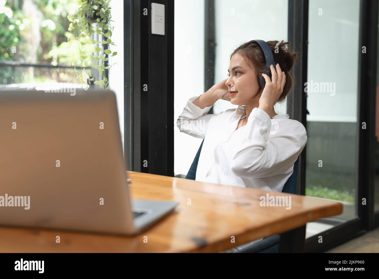 Online education, e-learning. young woman studying remotely, using a laptop, listening to online webinar at home Stock Photo