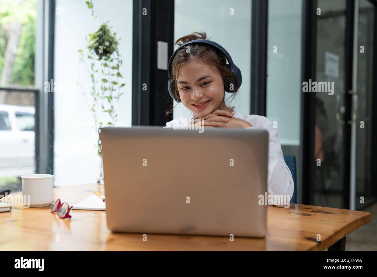 Online education, e-learning. young woman studying remotely, using a laptop, listening to online webinar at home Stock Photo