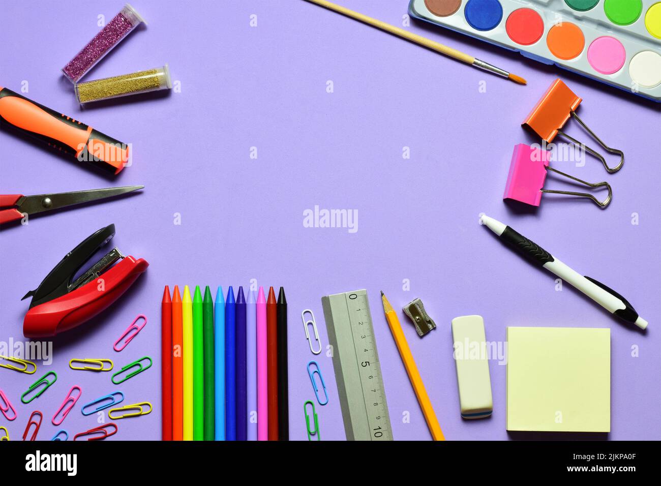 a Top view shot of stationary items on a purple background and copy