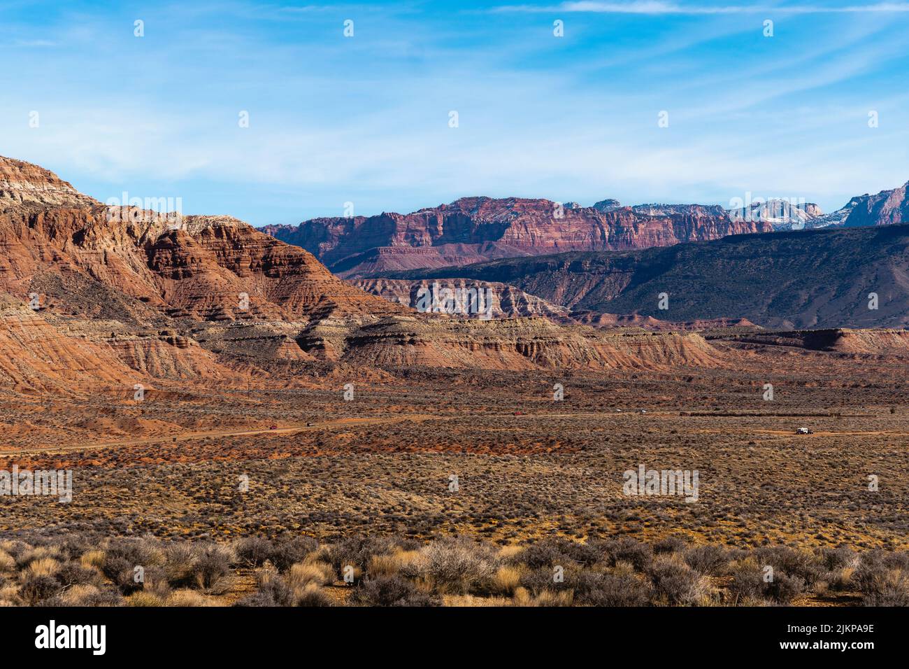 An arid desert view with rocky mountains under a cloudy blue sky Stock ...