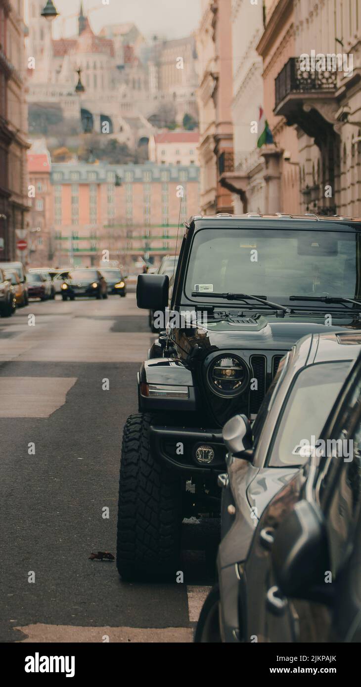 A vertical shot of cars parked in a street of a european city with ...