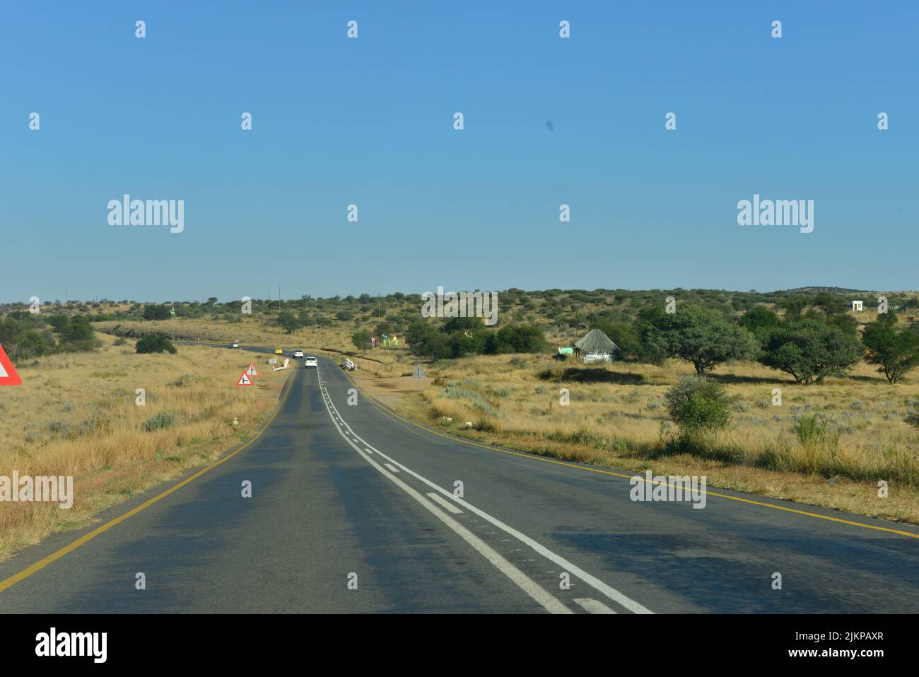 The long rural road with traffic and street signs in Windhoek, Namibia Stock Photo