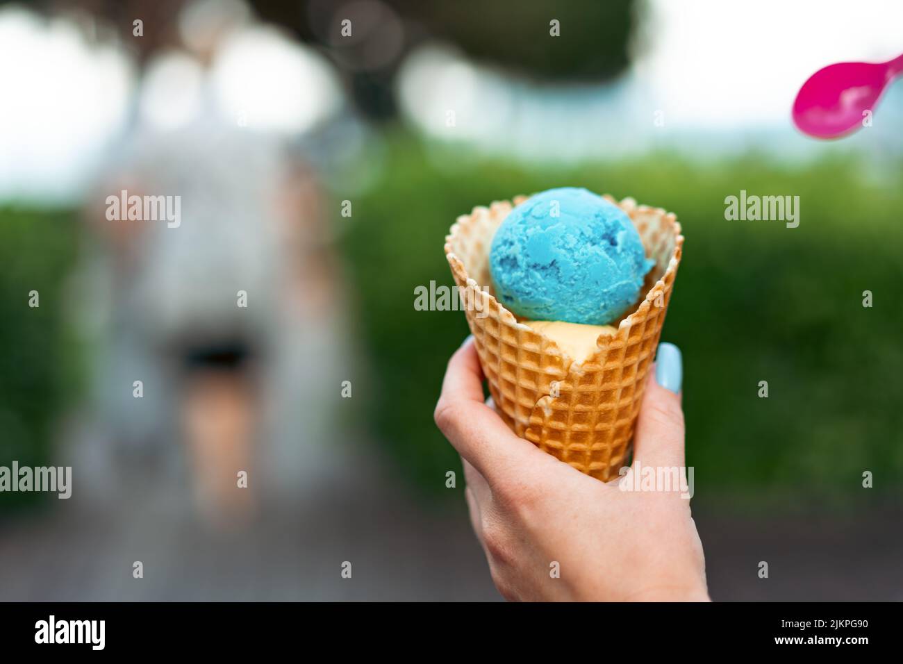 Woman's hand holding blue ice cream in waffle cone Stock Photo - Alamy