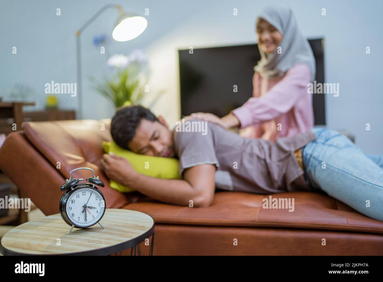 wife waking her husband up in the bed to have a breakfast Stock Photo