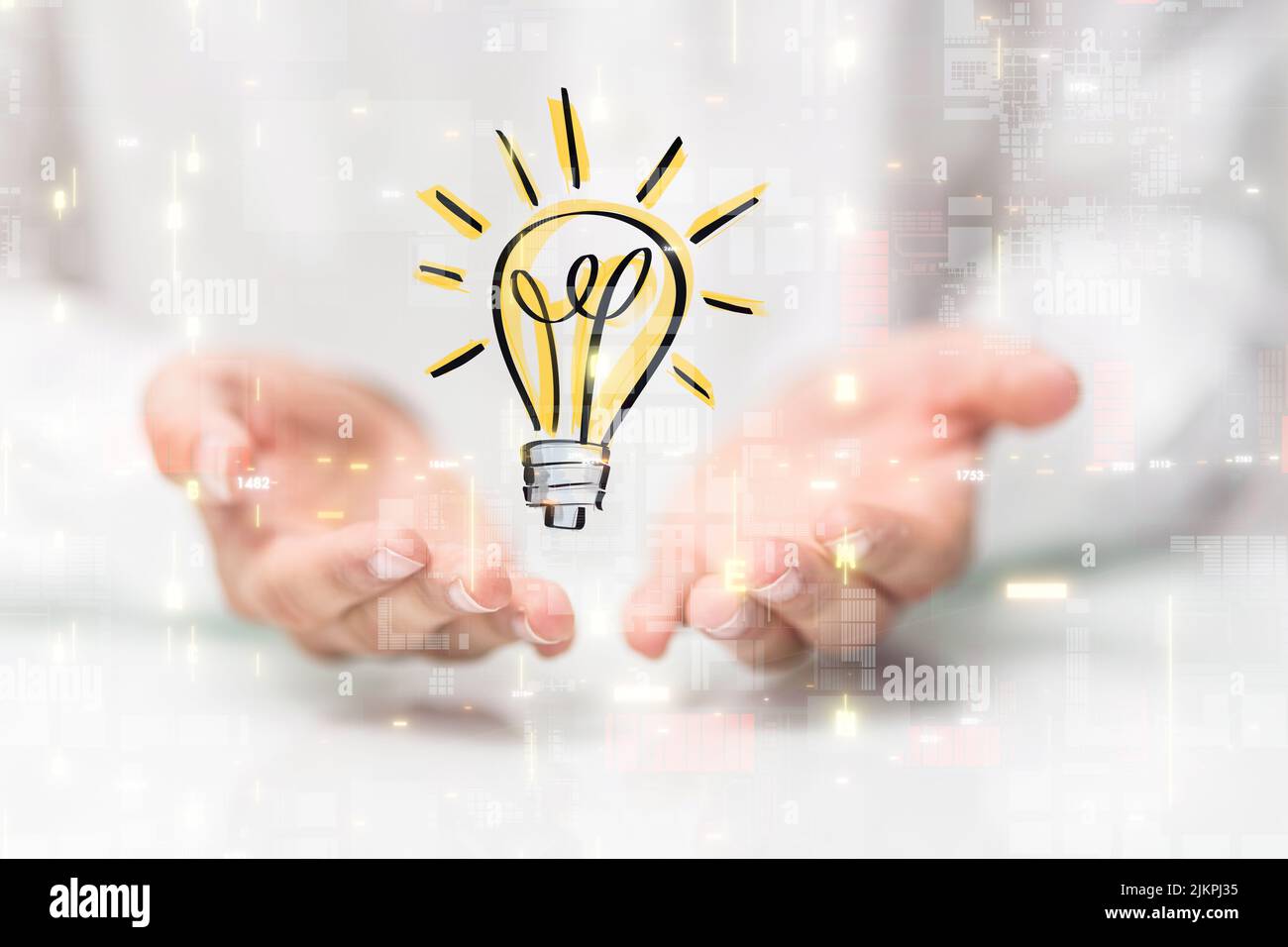 A hovering lightbulb icon floating on man's hands against a blurry white background Stock Photo