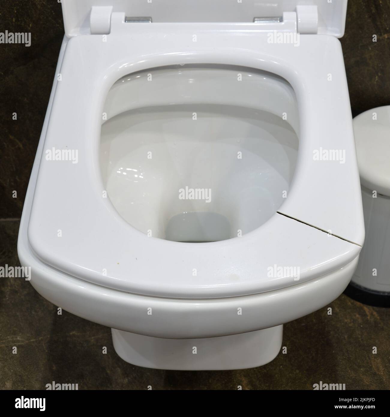 Cracked white toilet seat. A broken seat in the home toilet Stock Photo