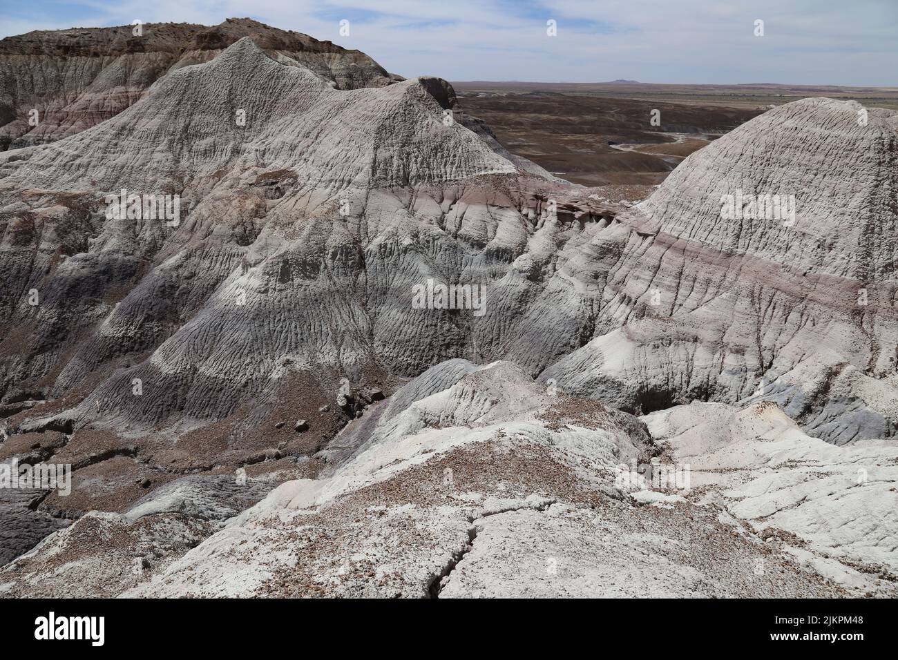 A dry landscape of striped rough rock formations in a desert under the ...