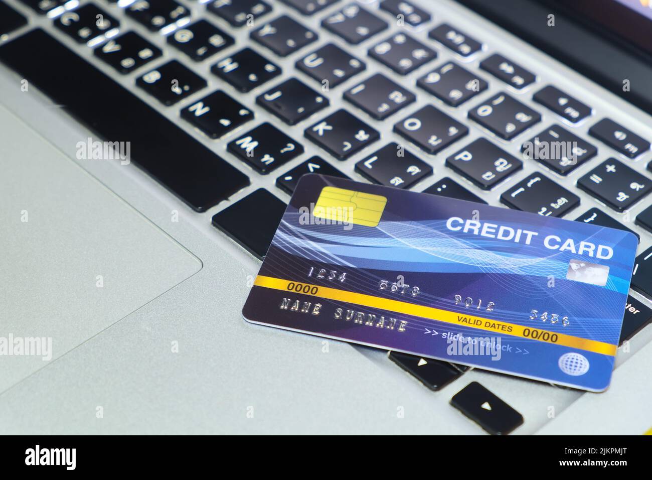Blue credit card mockup on locked mode put on keyboard of modern laptop