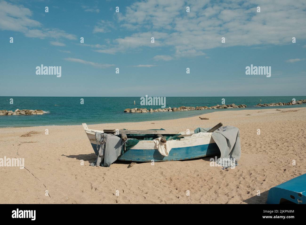 A blue and white fishing boat on the beach Stock Photo - Alamy