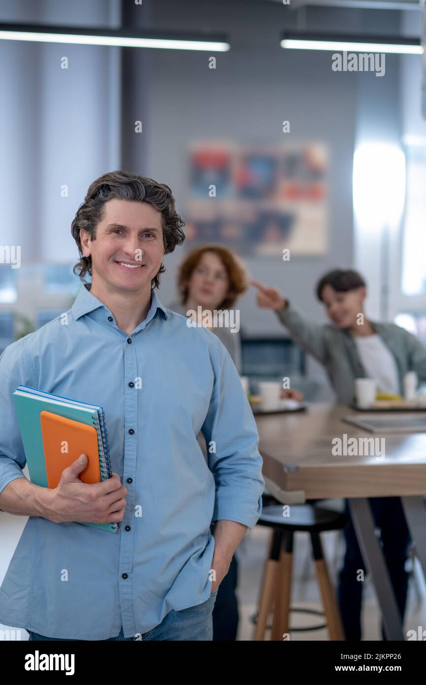 A smiling male teacher in a school canteen Stock Photo