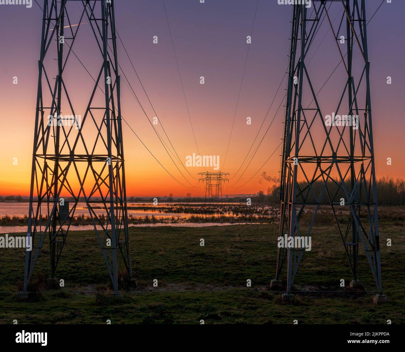 The high voltage transmission towers against scenic sunset Stock Photo ...