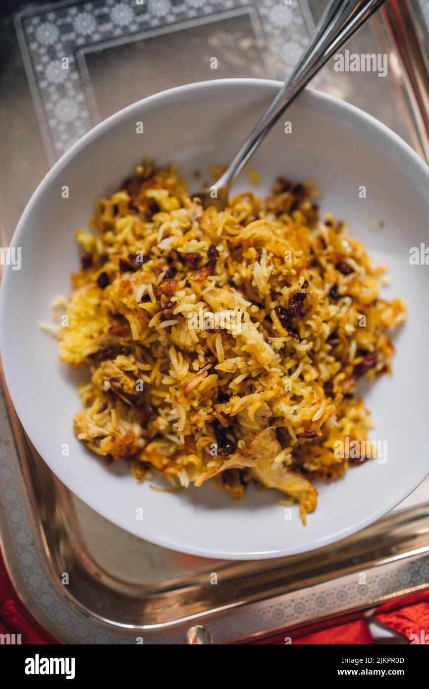 Persian Saffron Barberry Rice with Chicken single serving on white dish (Zereshk Polo ba morgh Irani) Stock Photo