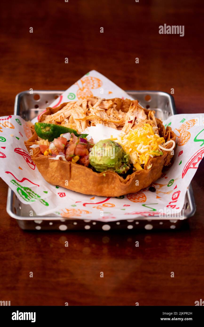 A Mexican chicken bowl with beans, guacamole, pico de gallo, and sour cream Stock Photo