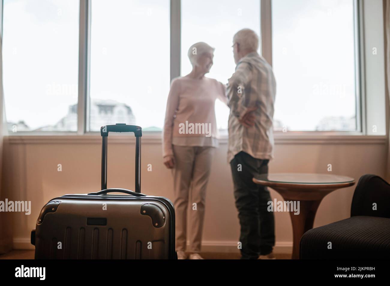Senior couple standing near the window and looking happy Stock Photo