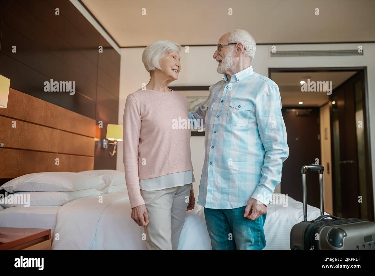 Senior happy couple in a hotel room looking cheerful and excited Stock Photo