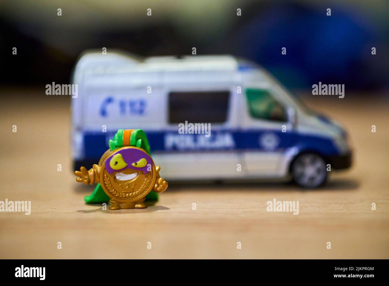 A closeup of Super Things medal shaped toy figurine of the evil team and a police van. Poznan Stock Photo