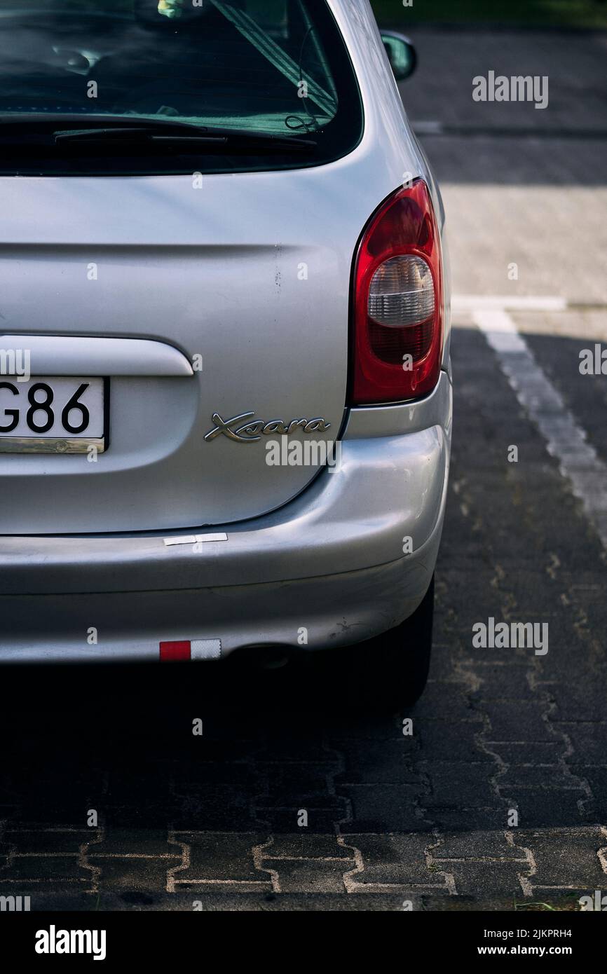 A vertical closeup of a parked Citroen Xsara car in a parking lot. Stock Photo