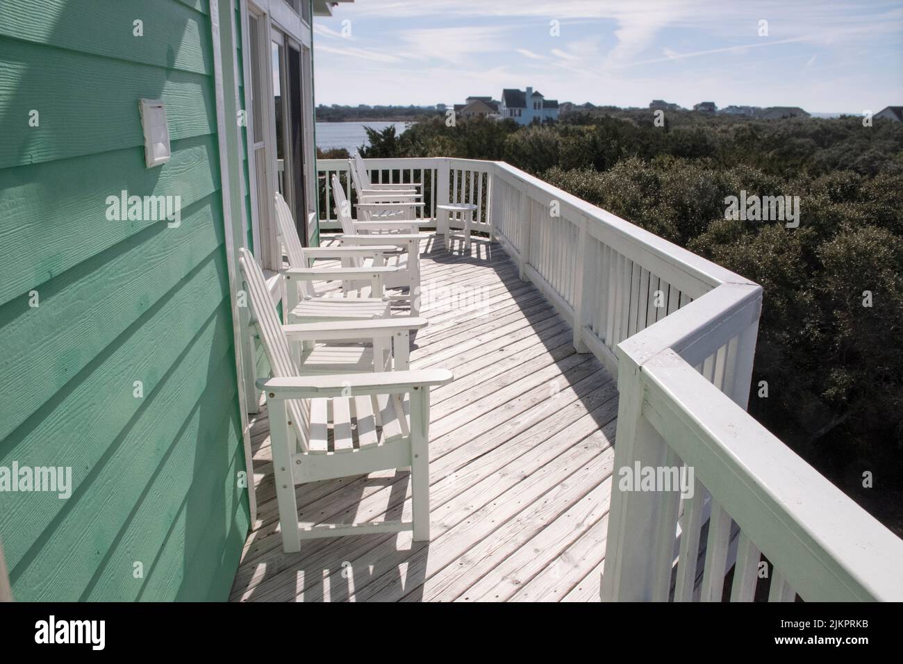 Deck chairs sit on the front deck of a house in the Outer Banks in preparation for the upcoming sunset Stock Photo