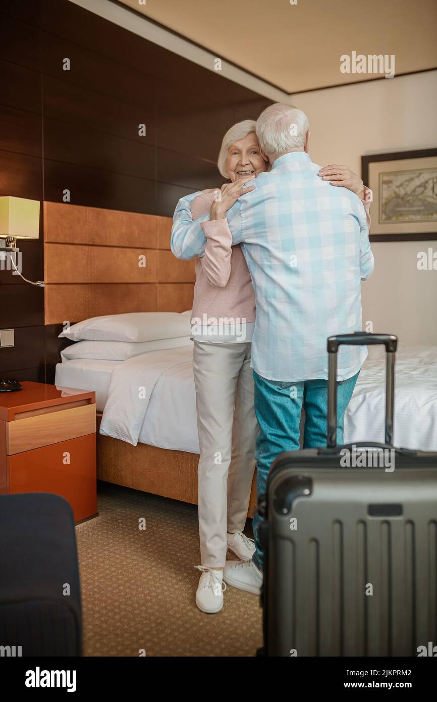 Gray-haired couple embracing and feeling happy Stock Photo