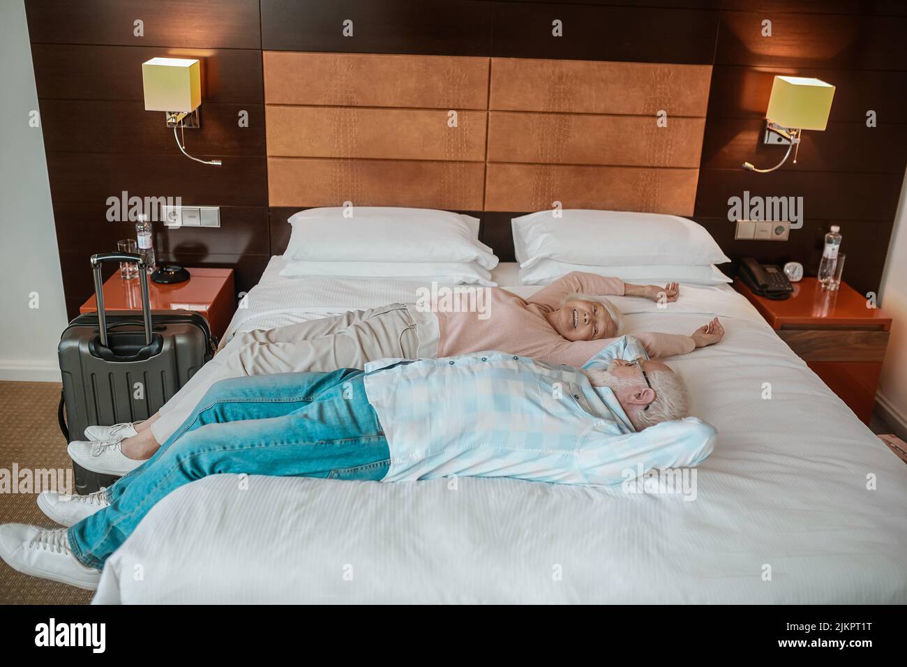 Two people lying on a bed and looking relaxed Stock Photo