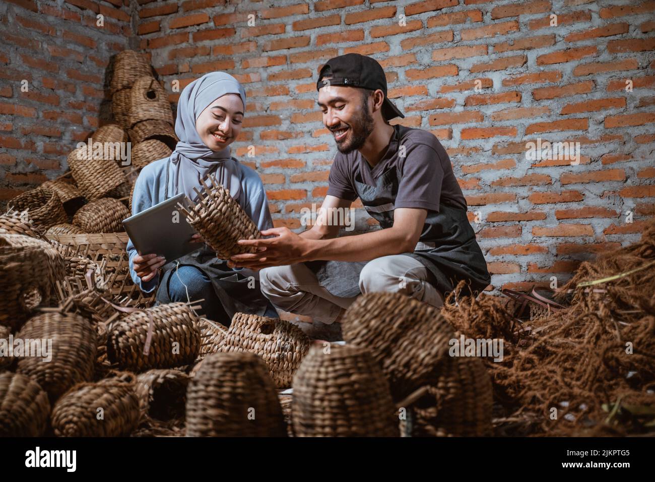craftswoman in veil holding tablet and craftsman holding a craft Stock ...