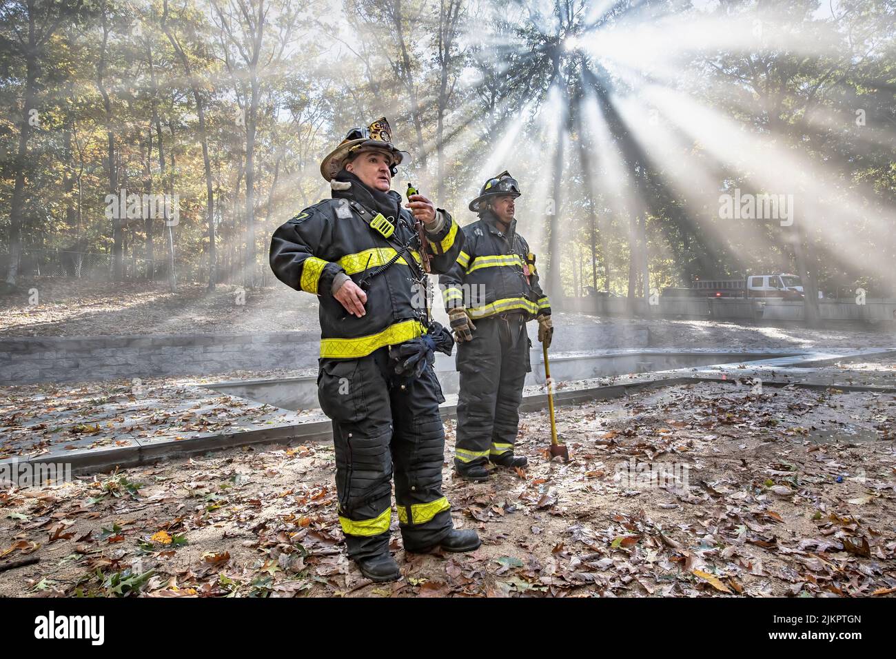 East Hampton Fire Department Chief Gerard Turza, Jr. issues orders over the radio from a vantage point in the rear yard as Sag Harbor Fire Department Stock Photo