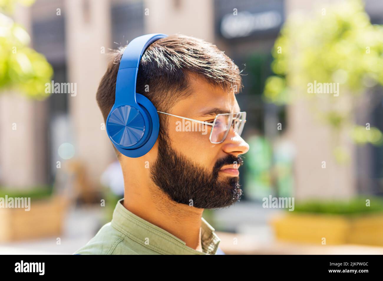 indian student with blue headset and backpack well looking at sunny day Stock Photo