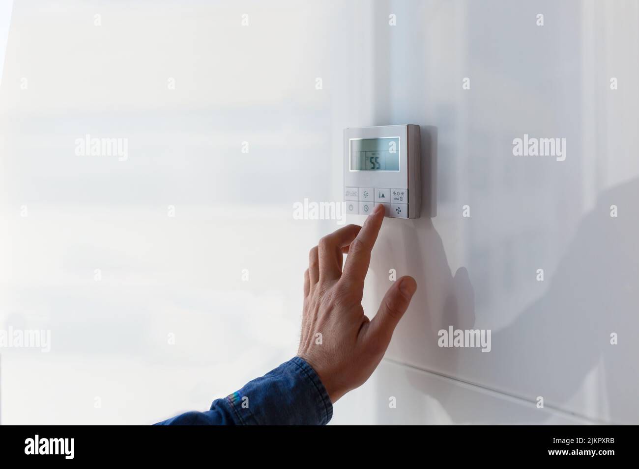 The air conditioning and heating control panel for the apartment and office is located on a white wall. Stock Photo